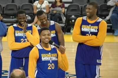 Kent Bazemore speaks at Warriors open practice with Green, Barnes, and Ezeli in background.jpg
