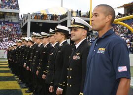 US Navy 091030-N-5366K-174 Special Warfare Operator 1st Class (SEAL) David Goggins stands at attention with members of the U.S. Naval Academy's triathlon team as they are recognized as Collegiate National Champions at the Navy.jpg