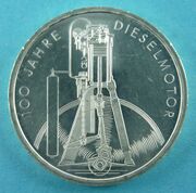 Аверс монеты 100 летие со дня создания Дизельного двигателя