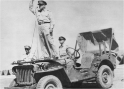 Полковник Т. ЦакалотосТ. Цакалотос на вседорожнике Willys MB держит речь перед солдатами 3-й Греческой бригады, перед отправкой в Италию, июнь 1944 года, Палестина