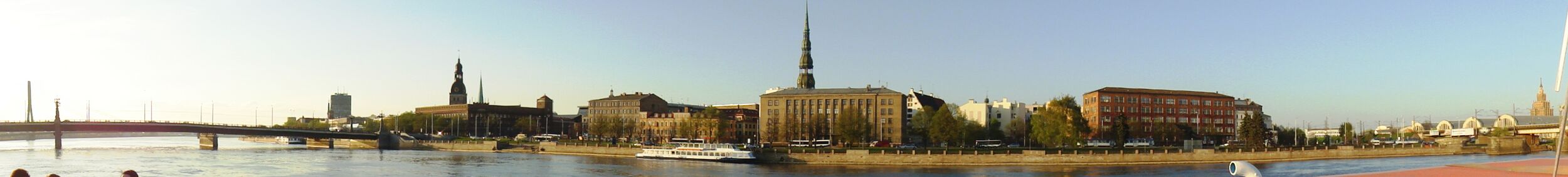 Набережная 11 Ноября. Слева&nbsp;— Каменный мост через Даугаву, правее него шпили Домского собора и церкви Св. Екаба. Здание в центре&nbsp;— Государственная земельная служба Латвии, за ней&nbsp;— шпиль церкви Св. Петра. Справа — Центральный рынок и здание Академии наук Латвии