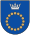 A coat of arms depicting a circle for which the boundary is itself made up of beige circles all under a silver crown on a blue background